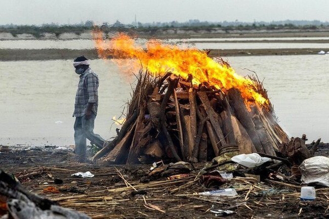 Thi thể người mắc COVID-19 hỏa táng bên bờ sông Hằng ở bang Uttar Pradesh. Ảnh: Reuters