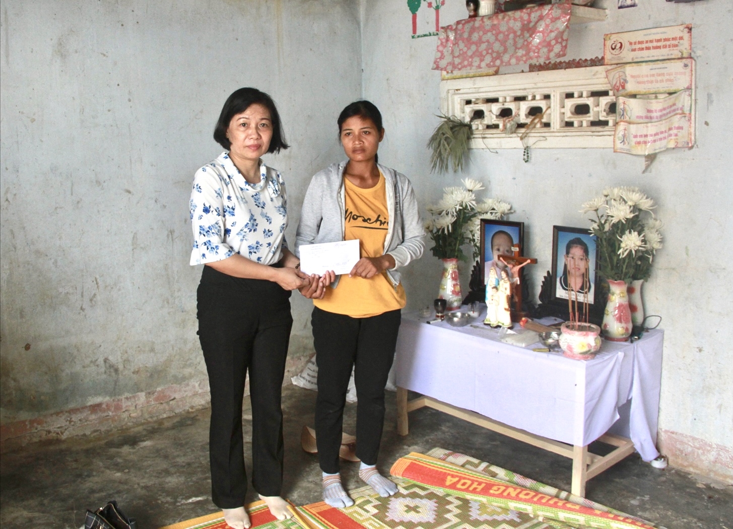 Bà Phạm Thị Phước An, Phó Vụ trưởng Vụ Địa phương II (Uỷ ban Dân tộc ) trao tiền hỗ trợ cho gia đình các nạn nhân