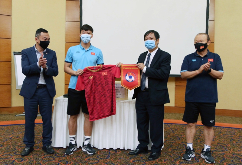 Đội trưởng Quế Ngọc Hải đại diện các cầu thủ đội tuyển tặng áo thi đấu, cờ lưu niệm cho Đại sứ Nguyễn Mạnh Tuấn. (Ảnh: VFF)