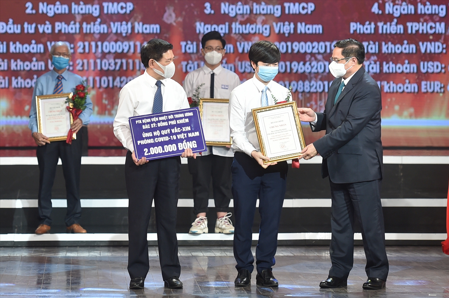 Thủ tướng Chính phủ Phạm Minh Chính trao chứng nhận, hoa cảm ơn Bác sĩ Đồng Phú Khiêm, Phó trưởng khoa điều trị tích cực - Bệnh viện Bệnh Nhiệt đới Trung ương. Ảnh: VGP