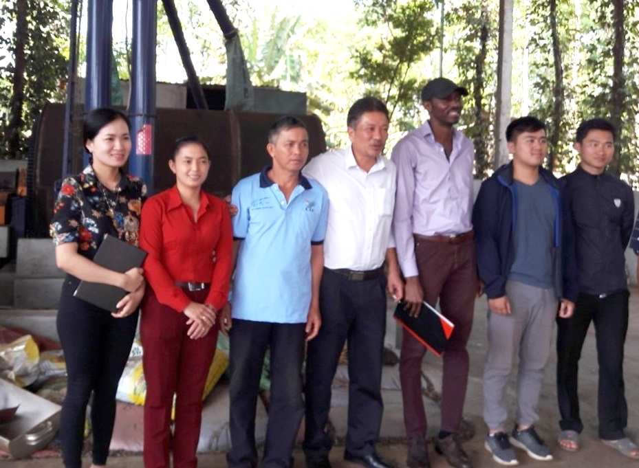 Triệu Thị Châu (thứ hai bên trái) và thành viên HTX Bình Minh chụp ảnh lưu niệm với đại biểu của Tập đoàn cà phê Newman vào thăm Nhà máy sấy - đốt biochar của HTX Bình Minh (Ảnh do nhân vật cung cấp)