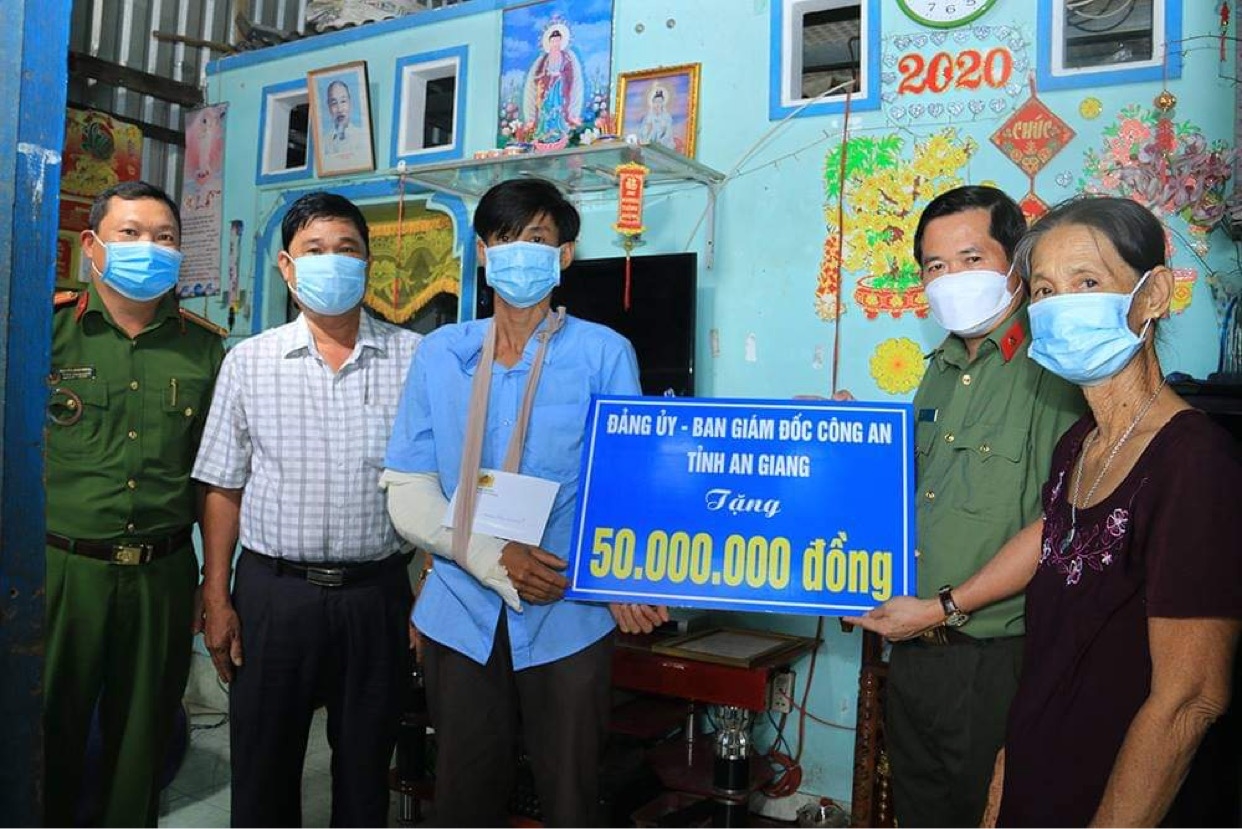Đại tá Đinh Văn Nơi, Giám đốc Công an tỉnh An Giang trao tượng trưng hỗ trợ 50 triệu đồng cho gia đình anh Đạo.