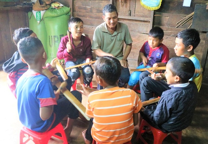 Nghệ nhân Y Gõ Niê truyền dạy cho lớp trẻ trong buôn Kram cách đánh chiêng.