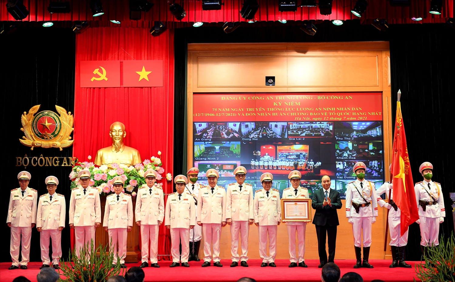 Chủ tịch nước Nguyễn Xuân Phúc gắn Huân chương lên Cờ truyền thống và trao Bằng Huân chương Bảo vệ Tổ quốc hạng Nhất tặng lực lượng ANND - Ảnh VGP/Đức Tuân 