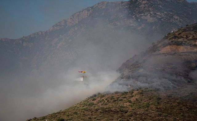 Máy bay trực thăng dội bom nước nhằm khống chế ngọn lửa. (Ảnh: Reuters)