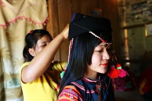 Các thiếu nữ dân tộc Hà Nhì chuẩn bị trang phục đi chơi tết. Ảnh: Phan Tuấn Anh - TTXVN