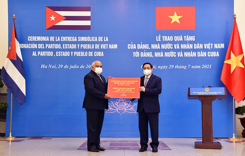 Thay mặt Đảng, Nhà nước và nhân dân Việt Nam, Thủ tướng Phạm Minh Chính trao tượng trưng món quà 10.000 tấn gạo tặng Đảng, Nhà nước và nhân dân Cuba. Ảnh: VGP/Nhật Bắc