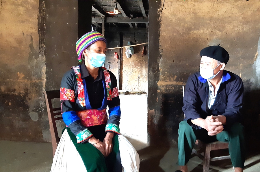 Người có uy tín Lục Xuân Thành (phải), thôn Bó Lách tuyên truyền người dân cách phòng, chống dịch bệnh Covid-19