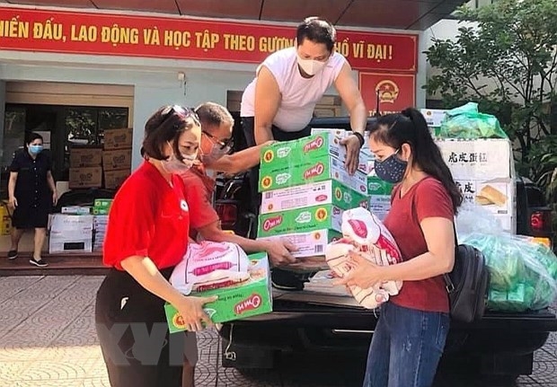 Hội Chữ thập đỏ quận Ba Đình tặng các phần quà hộ trợ tới lực lượng tuyến đầu tại các chốt phòng dịch và người dân bị ảnh ảnh hưởng trên địa bàn quận. Ảnh: TTXVN