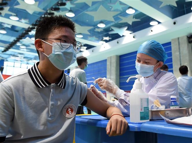 Nhân viên y tế tiêm vaccine phòng COVID-19 cho học sinh tại Trịnh Châu, tỉnh Hà Nam, Trung Quốc, ngày 19/8/2021. Ảnh: THX/TTXVN
