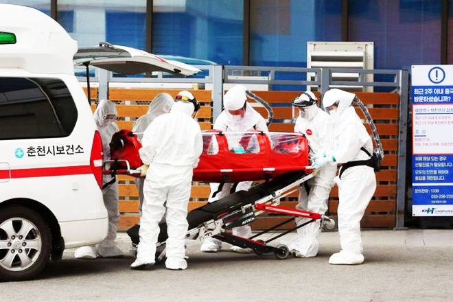 Nhân viên y tế tại bệnh viện ở Hàn Quốc vận chuyển bệnh nhân nhiễm Covid-19 (Ảnh: AFP).