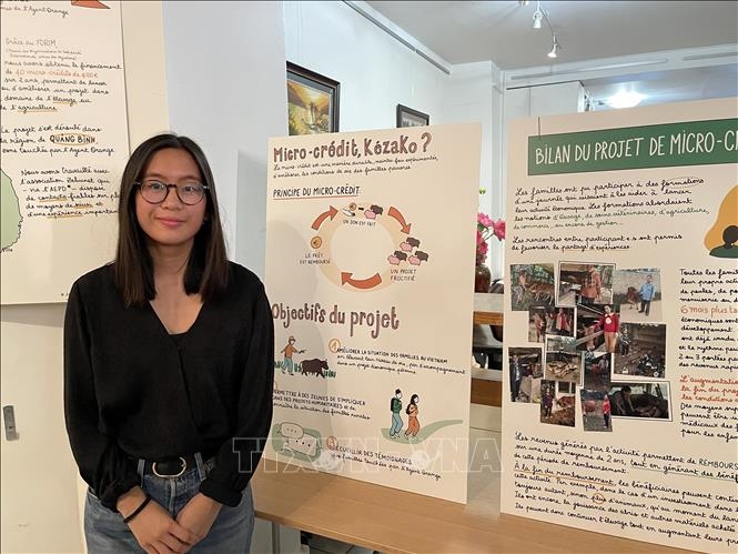 Họa sĩ Trâm Anh bên tranh đồ họa giới thiệu dự án tín dụng nhỏ giúp đỡ các gia đình nạn nhân chất độc da cam/dioxin ở Việt Nam