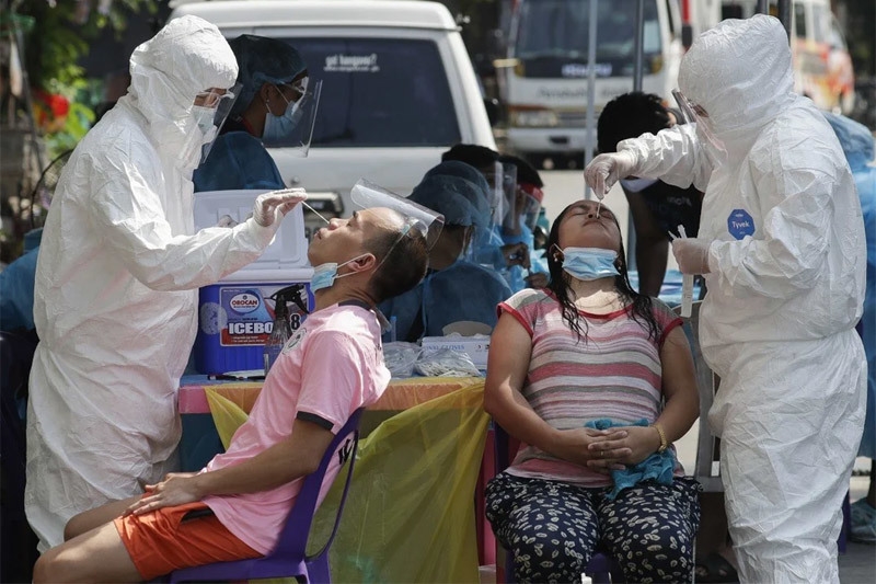 Nhân viên y tế đang lấy mẫu xét nghiệm Covid-19 cho người dân ở thành phố Quezon, Philippines. Ảnh: AP