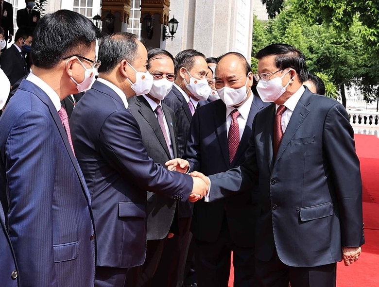 Chủ tịch nước Nguyễn Xuân Phúc và Tổng Bí thư, Chủ tịch nước Lào Thongloun Sisoulith với các thành viên đoàn đại biểu cấp cao 2 nước tại lễ đón. (Nguồn: TTXVN) 