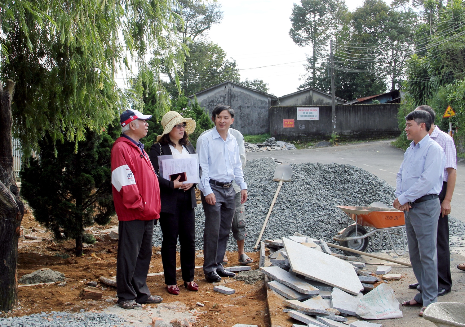 Linh muc Dương Công Hồ (bìa trái) trò chuyện với lãnh đạo địa phương trong quá trình cùng người dân xây dựng vỉa hè khu dân cư