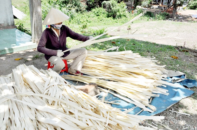 Bà Lê Thị Xuân, 44 tuổi, ngụ xã Xuân Hưng, huyện Xuân Lộc thực hiện công đoạn chuốt lá buông