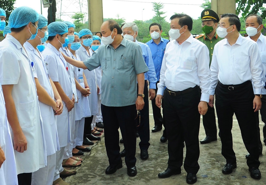 Chủ tịch nước Nguyễn Xuân Phúc động viên các nhân viên y tế làm việc tại cơ sở thu dung, điều trị bệnh nhân COVID-19 của Bệnh viện Đa khoa Hà Đông tại phường Hoàng Liệt, quận Hoàng Mai