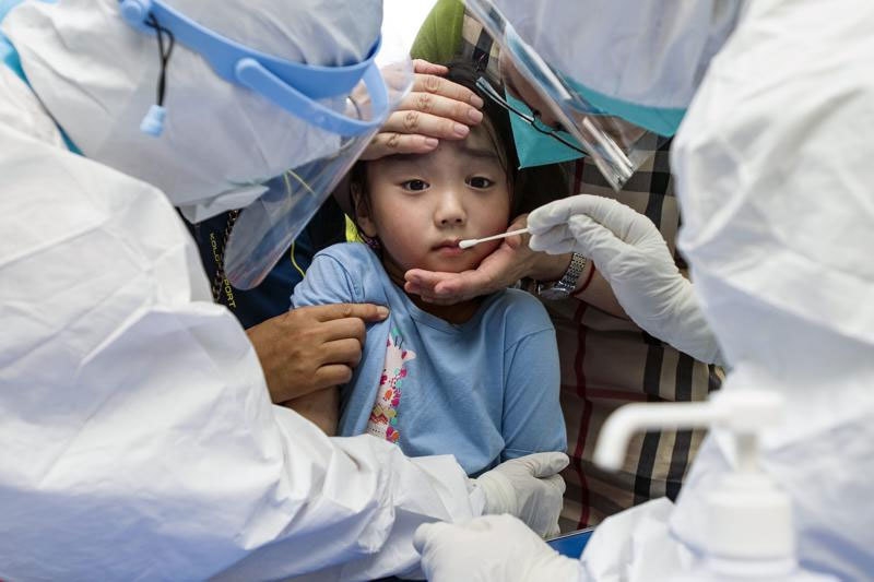 Một em bé được lấy mẫu xét nghiệm Covid-19 ở Vũ Hán, Trung Quốc, hôm 3/8. Ảnh: AP