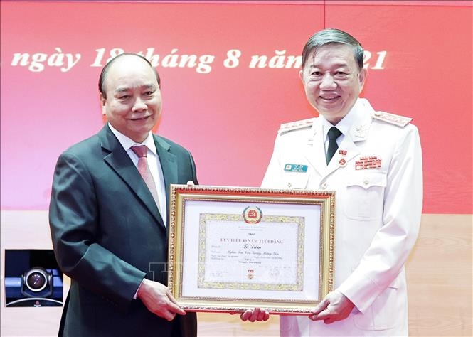 Chủ tịch nước Nguyễn Xuân Phúc trao tặng Huy hiệu 40 năm tuổi Đảng cho Đại tướng Tô Lâm, Uỷ viên Bộ Chính trị, Bộ trưởng Bộ Công an. Ảnh: TTXVN