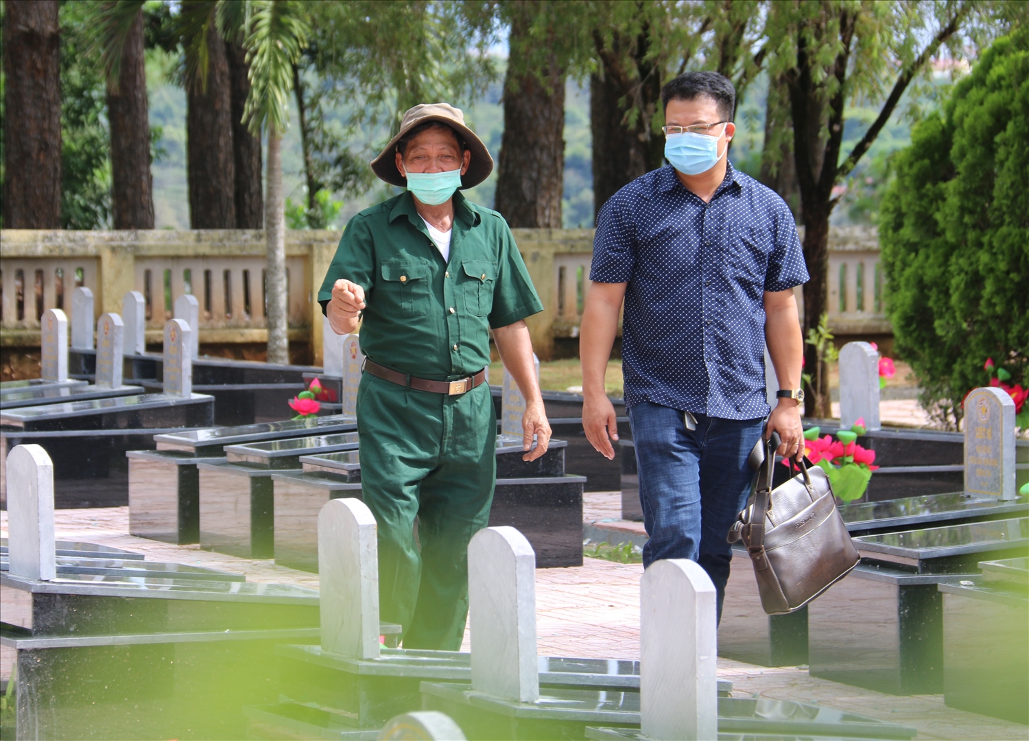 Cựu chiến binh Phùng Văn Toàn (bên trái) ngày ngày chăm sóc Nghĩa trang Liệt sĩ tỉnh Đắk Nông