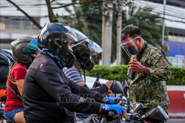 Cảnh sát kiểm tra người lưu thông nhằm đảm bảo người dân tuân thủ quy định phòng chống dịch COVID-19 tại một chốt kiểm soát ở thành phố Quezon, Philippines ngày 6/8/2021. Ảnh: THX/TTXVN
