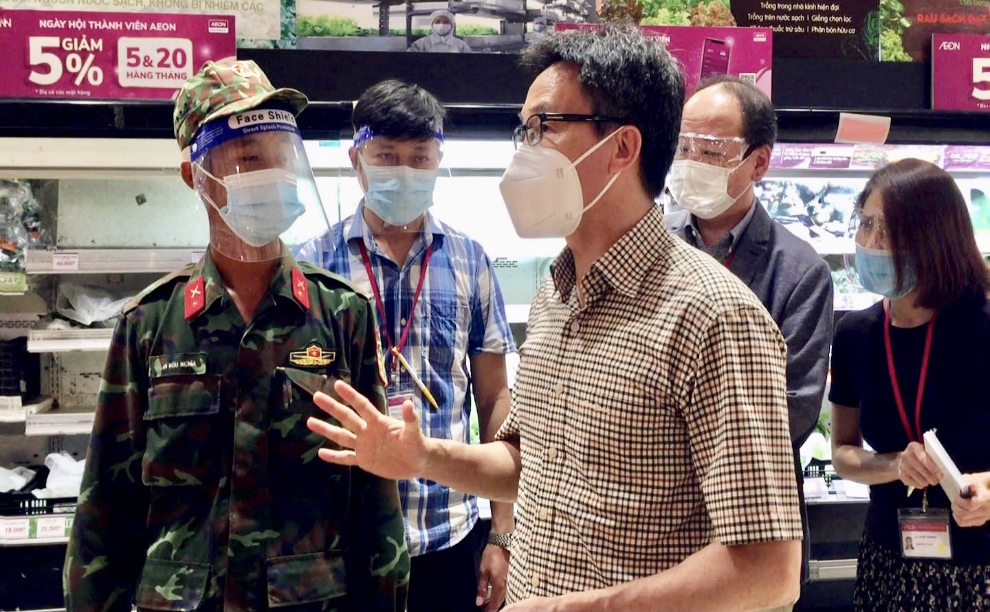 Phó Thủ tướng trò chuyện với một chiến sĩ “đi chợ hộ” cho người dân. Ảnh VGP/Đình Nam