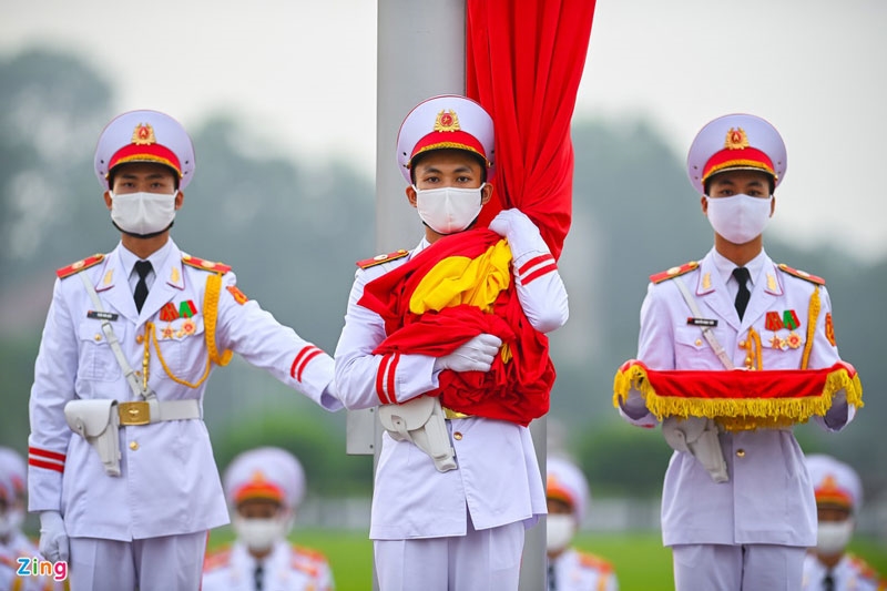 3 chiến sĩ của đội hồng kỳ nghiêm trang bước lên bục để chuẩn bị thực hiện các nghi thức chính. Lúc 5h59, chiến sĩ mang Quốc kỳ treo lên cột cờ.