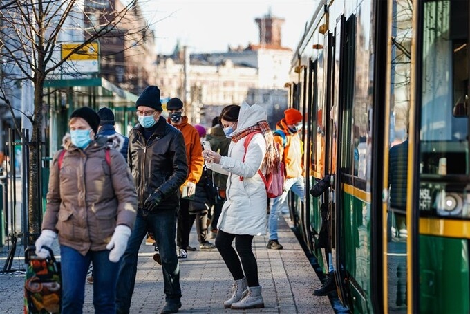 Người dân tại một trạm dừng xe điện ở Phần Lan. Ảnh: Bloomberg.