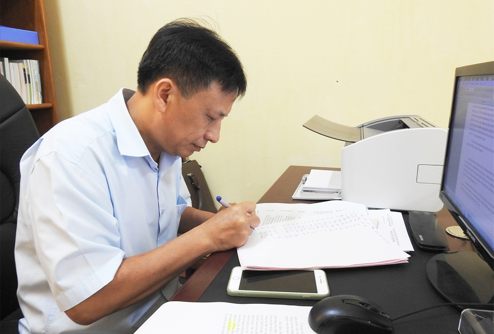Ông Cao Văn Chỉ, Trưởng phòng LĐTB&XH huyện Văn Yên đang thống kê số đơn thoát nghèo của huyện