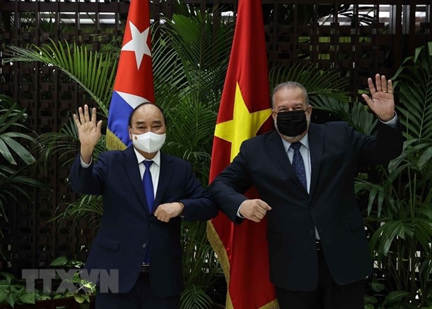 Chủ tịch nước Nguyễn Xuân Phúc và Thủ tướng Cộng hòa Cuba Manuel Marrero Cruz vẫy tay chào. (Ảnh: Thống Nhất/TTXVN)