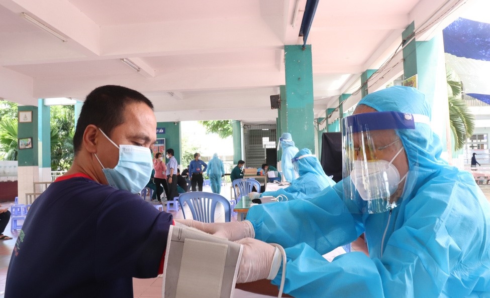 Bác sĩ về hưu Phạm Biên nhanh nhẹn đo huyết áp cho người dân trước khi tiêm vắc xin COVID-19 