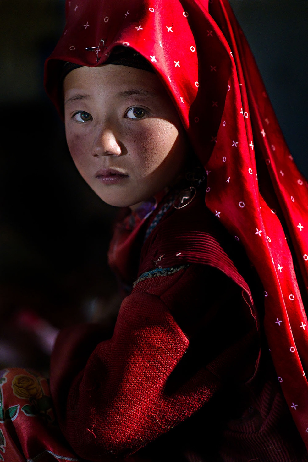 Cô gái đội khăn trong bộ ảnh "My Red Pamir" của Nicola Ducati. Tác giả cho biết lần đầu tiên ông gặp những người phụ nữ mặc đồ đỏ ở vùng núi cao của Afghanistan. Ông cho biết họ "sống trong khói bụi của những sa mạc nhưng trông như những nữ hoàng" - Ảnh: Nicola Ducati/AAP