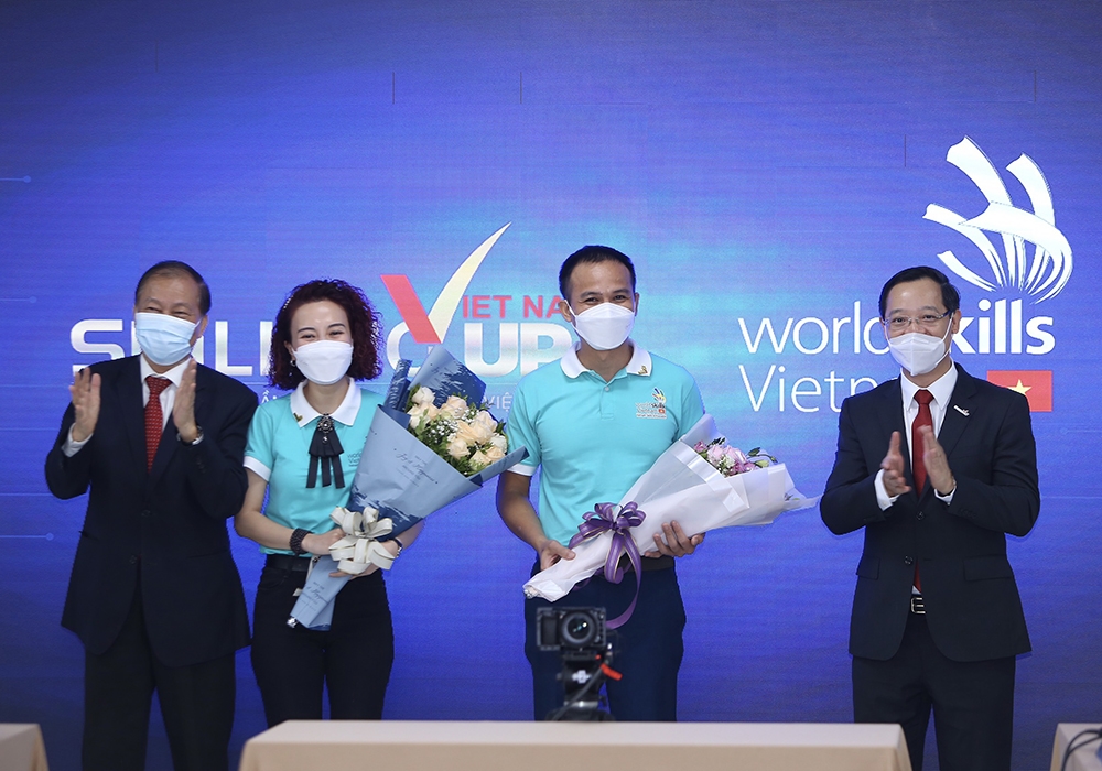 Tổng cục Trưởng Tổng cục GDNN Trương Anh Dũng (bên phải) và Phó Chủ tịch VCCI Hoàng Quang Phòng tặng hoa chúc mừng các Đại sứ kỹ năng nghề