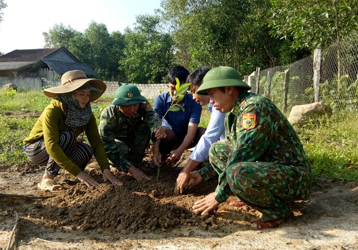 Cán bộ, chiến sĩ Đồn Biên phòng hỗ trợ cây giống, hướng dân kỹ thuật trồng và chăm bón cho người dân khu TĐC