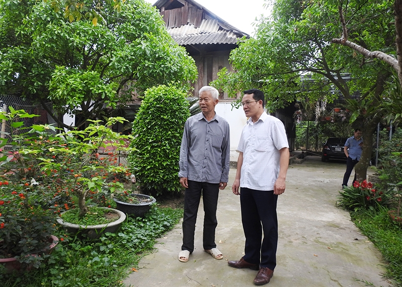 Ông Lường Trung Lập (bên trái) giới thiệu mô hình kinh tế của gia đình tới cán bộ thị xã Nghĩa Lộ. (Ảnh chụp trước ngày 27/4/2021)