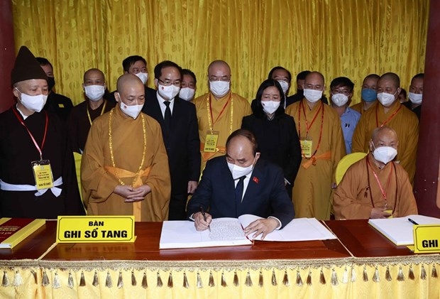 Chủ tịch nước Nguyễn Xuân Phúc ghi Sổ tang tại Lễ viếng Đại lão Hòa thượng Thích Phổ Tuệ. (Ảnh: Thống Nhất/TTXVN)