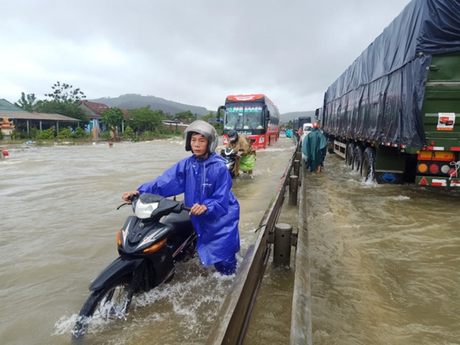 Quốc lộ 1A đoạn qua xã Lộc Trì, huyện Phú Lộc (Thừa Thiên- Huế) bị ngập, người đi xe gắn máy phải dắt bộ. (Ảnh: Báo điện tử Người lao động)