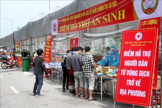 Tại điểm trung chuyển, công dân từ các tỉnh phía Nam về quê bằng xe máy qua địa phận tỉnh Nghệ An được hỗ trợ đồ ăn nhanh, nước uống, xăng... miễn phí, ngày 9/10/2021. Ảnh minh họa: Văn Tý/TTXVN