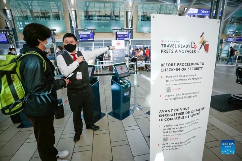 Nhân viên hàng không hỗ trợ hành khách tại sảnh khởi hành của Sân bay Quốc tế Vancouver, Canada, ngày 30/1/2021. Bắt đầu từ cuối tuần trước, du khách từ 12 tuổi trở lên cần cung cấp chứng nhận tiêm phòng đầy đủ vaccine COVID-19 trước khi thực hiện các chuyến bay. (Ảnh: Xinhua)