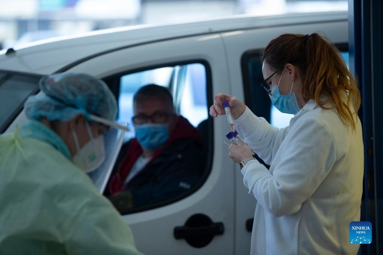 Nhân viên y tế xét nghiệm COVID-19 cho lái xe tại một trạm lưu động ở Ljubljana, Slovenia, ngày 4/11/2021. (Ảnh: Xinhua)
