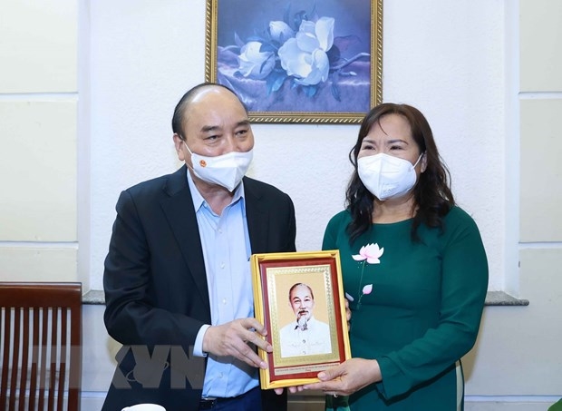 Chủ tịch nước Nguyễn Xuân Phúc thăm tặng quà cho thạc sỹ nhà giáo Triệu Thị Huệ, sinh năm 1965, sống tại phường 15, quận 5, TP. Hồ Chí Minh. (Ảnh: Thống Nhất/TTXVN)