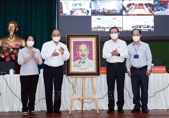 Chủ tịch nước Nguyễn Xuân Phúc tặng quà lưu niệm cho Quận 1. Ảnh: Thống Nhất/TTXVN