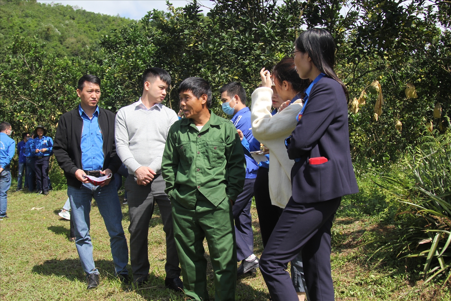 Ông Đinh Duy Lý (đứng giữa) giới thiệu về trang trại của mình cho đoàn tham quan