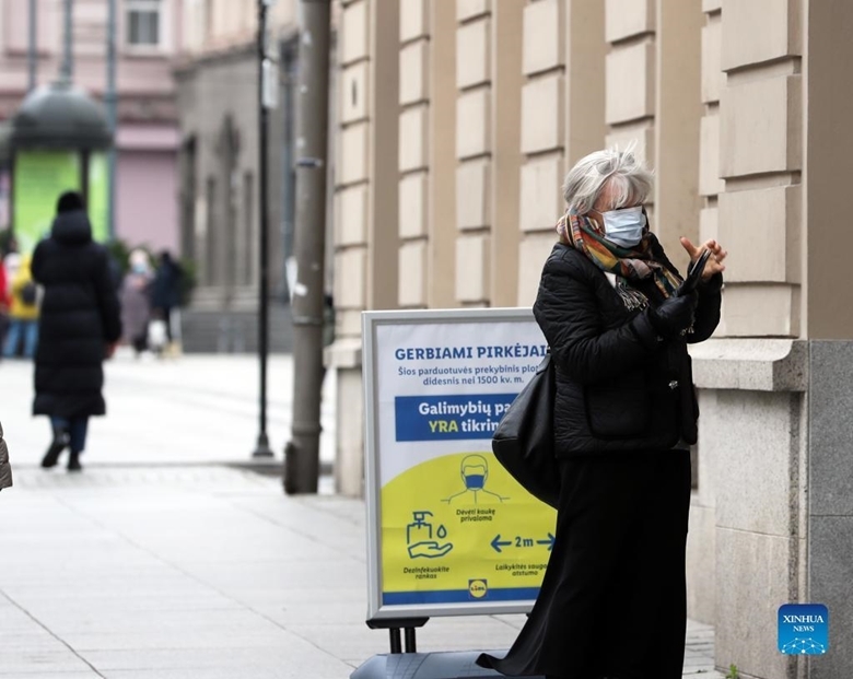 Một người phụ nữ đeo khẩu trang khi bước vào một tòa nhà ở thủ đô Vilnius của Litva, ngày 15/11/2021.(Ảnh: Xinhua)