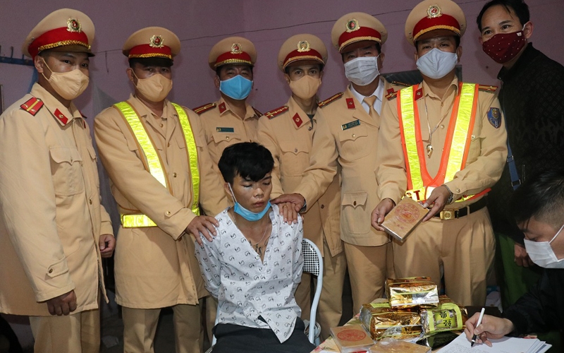 Tòng Văn Dính cùng tang vật khi bị lực lượng Cảnh sát giao thông Công an tỉnh Điện Biên bắt giữ