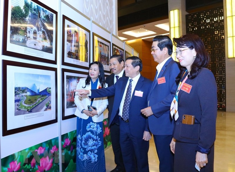 Các đại biểu tham quan triển lãm ảnh được trưng bày tại Hội nghị. Ảnh: TTXVN