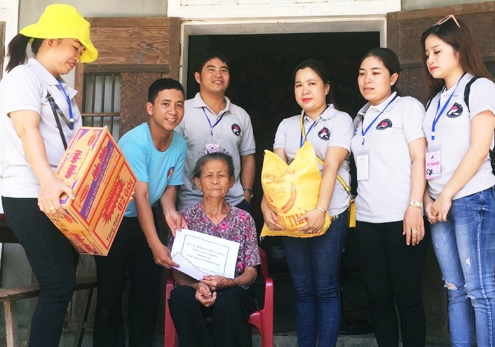 Anh Lê Văn Đinh (thứ 2 từ trái sang) cùng các tình nguyện viên trao quà cho một hoàn cảnh khó khăn. (Ảnh NVCC)