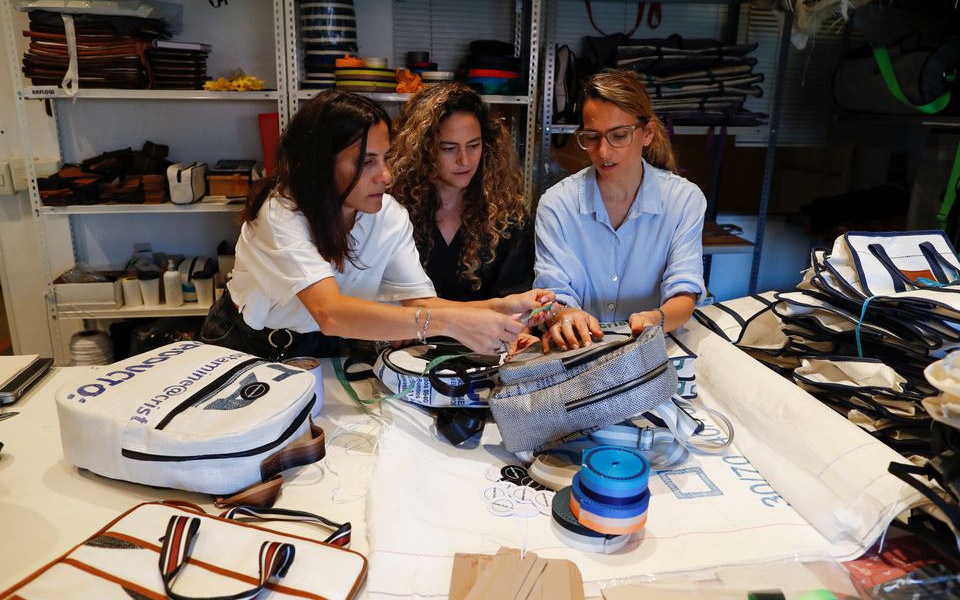 Ba chị em gái, ba nhà sáng lập hãng thời trang đang trao đổi về thiết kế của các sản phẩm từ túi thải. (Ảnh: Reuters)