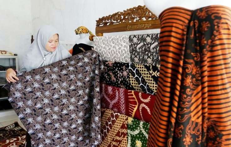 Một chủ tiệm trưng bày vải Batik đang giới thiệu về các họa tiết và chất liệu vải Batik 
