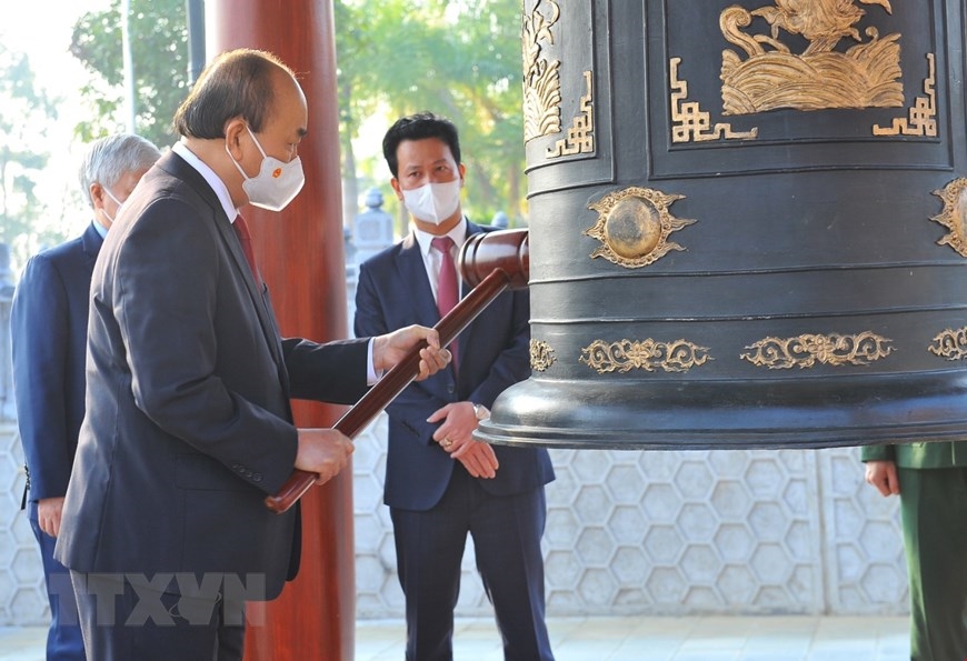 Chủ tịch nước Nguyễn Xuân Phúc thỉnh chuông tại Nghĩa trang Liệt sĩ Quốc gia Vị Xuyên. (Ảnh: Minh Đức/TTXVN) 